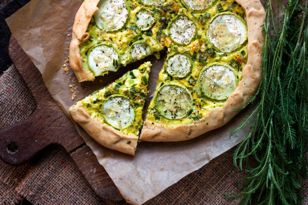 istock Homemade courgette and goat cheese pie on a dark rustic wooden board background 1172289849