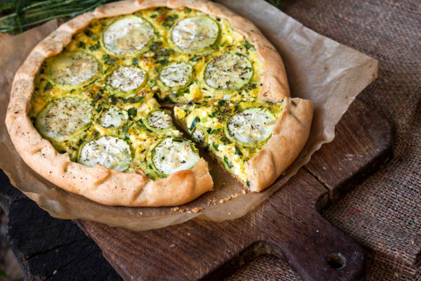 istock Homemade courgette and goat cheese pie on a dark rustic wooden board background 1172290708