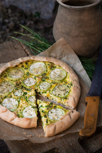 istock Homemade courgette and goat cheese pie on a dark rustic wooden board background 1172290997