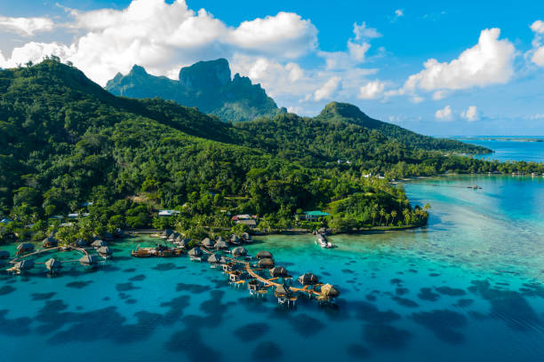 Bora Bora aerial drone image of travel vacation paradise and overwater bungalows Bora Bora aerial drone video of travel vacation paradise with overwater bungalows luxury resort, coral reef lagoon ocean beach. Mount Otemanu, Bora Bora, French Polynesia, Tahiti, South Pacific Ocean pacific islands stock pictures, royalty-free photos & images