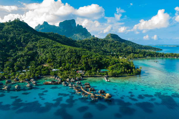 Bora Bora aerial drone image of travel vacation paradise and overwater bungalows Bora Bora aerial drone video of travel vacation paradise with overwater bungalows luxury resort, coral reef lagoon ocean beach. Mount Otemanu, Bora Bora, French Polynesia, Tahiti, South Pacific Ocean oceania stock pictures, royalty-free photos & images