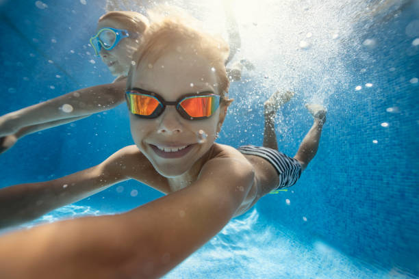 istock Happy kids swimming underwater in pool 1172292761