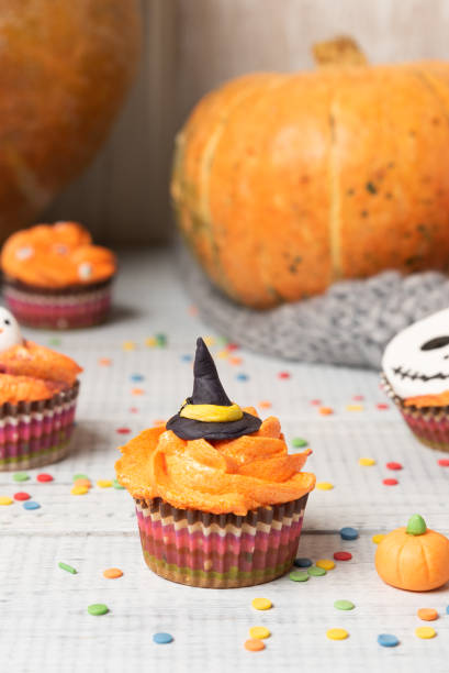 istock Halloween cupcakes decorated colored decorations witch hat, orange cream 1172293240