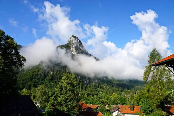 Oberammergau, Germany August 2019:  In the early morning, the Kofel deep hanging clouds, particularly after a rainy night.