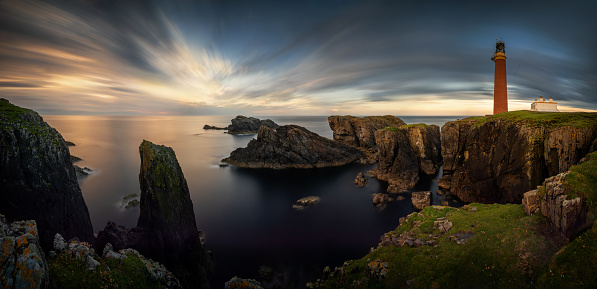 Panorama of Butt of Lewis lighthouse on high cliffs in sunset light, Scotland