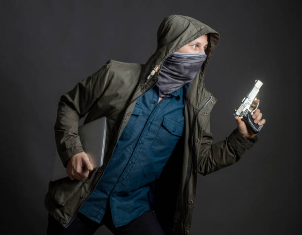 istock Gangster holding gun and laptop 1172308713