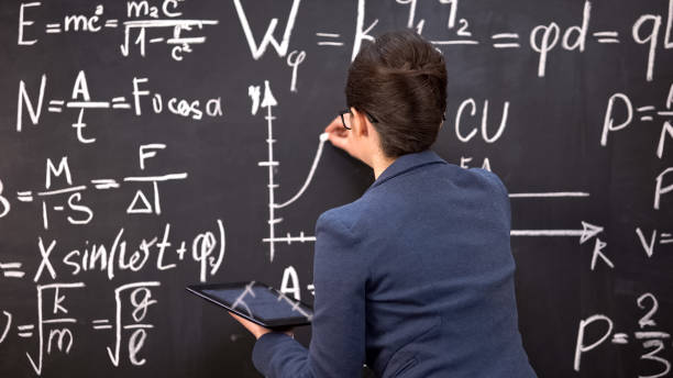 istock Female teacher drawing graph on chalkboard and holding tablet, innovations 1172312764
