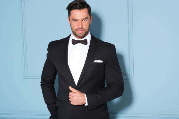 istock Elegant man in black classic suit posing in nice studio. 1172314719