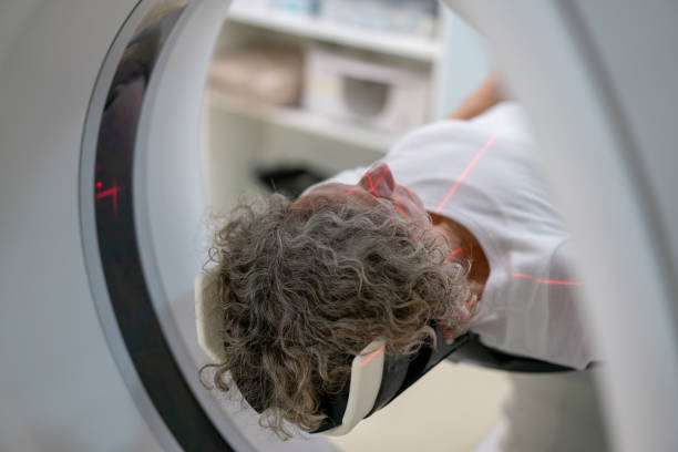istock Unrecognizable female senior patient lying on the CAT scan machine taking a brain scan 1172314761
