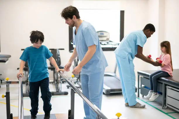 Kids during physical rehab each working with their physical therapist at the clinic - Healthcare concepts