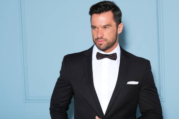 istock Elegant man in black classic suit posing in nice studio. 1172314861