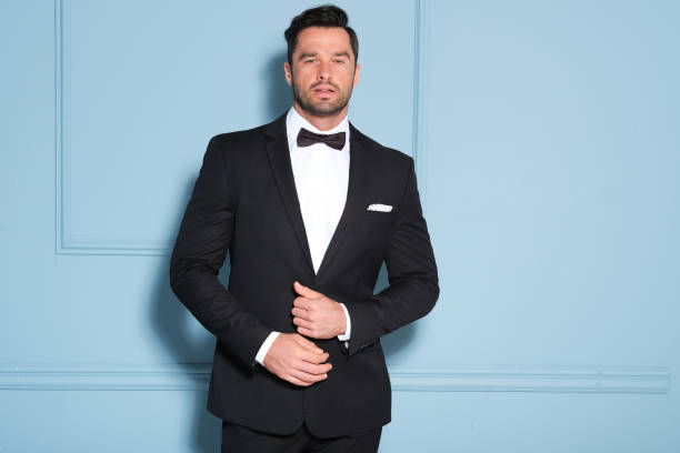 istock Elegant man in black classic suit posing in nice studio. 1172315015