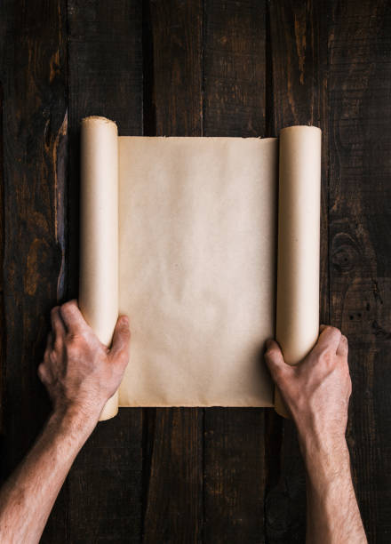 istock Male hands hold ancient paper roll 1172317295