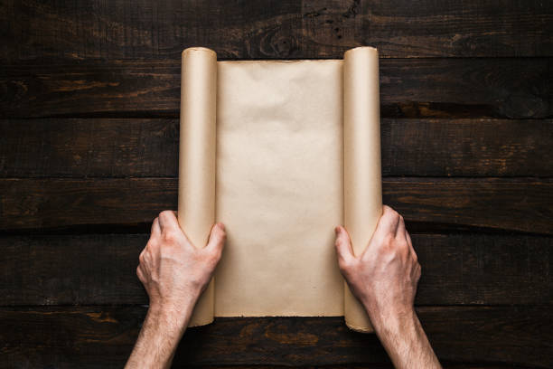 istock Male hands holding old paper scroll 1172317306