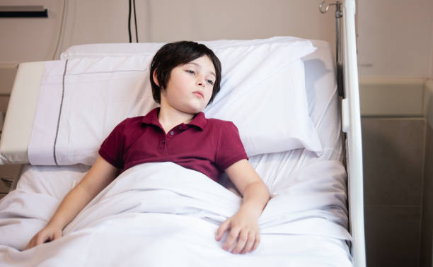 istock Sad little boy lying down on bed looking away hospitalized 1172318265