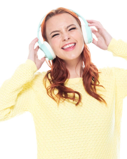 cintura acima de 18-19 anos de meninas adolescentes caucasianos das mulheres novas do redhead bonito velho na frente do fundo branco que desgasta calças de brim/camisola do cardigan que está sorrindo/feliz/alegre/que escuta que está suando e usando ausc - 18 19 years audio - fotografias e filmes do acervo