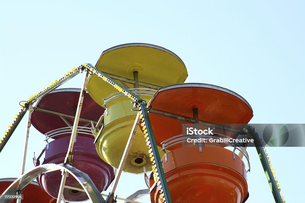 Vintage Ferris Wheel at the Carnival looks like Fiestaware bowls Ferris wheel cars against a blue sky. Adventure Stock Photo