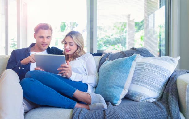istock Happy couple looking at a digital tablet coffee on the sofa. 1172331146
