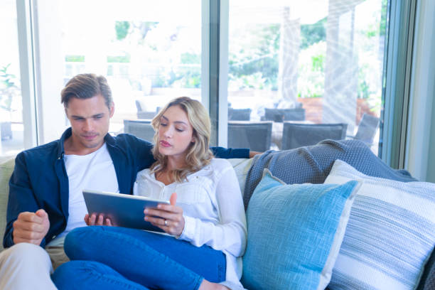 istock Worried couple looking at a digital tablet coffee on the sofa. 1172331152