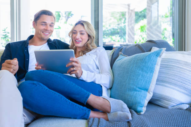 istock Happy couple looking at a digital tablet coffee on the sofa. 1172331155