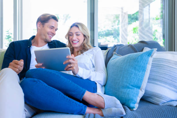 istock Happy couple looking at a digital tablet coffee on the sofa. 1172331158