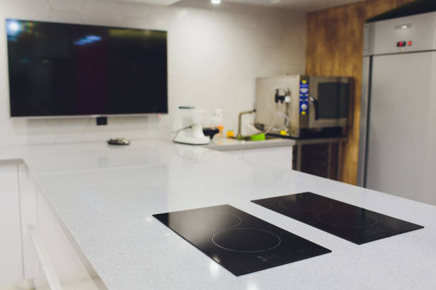 istock Modern black induction cooker on white countertop. kitchen with island. 1172334777
