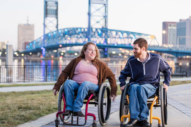 istock Couple in wheelchairs at city waterfront 1172335734
