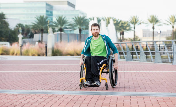 hombre con parálisis cerebral en silla de ruedas autopropulsada - physical impairment smiling front view looking at camera fotografías e imágenes de stock