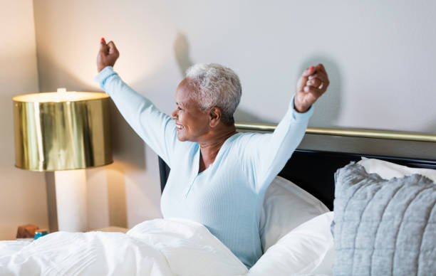 senior african-american woman waking up - wake up stretching women black imagens e fotografias de stock