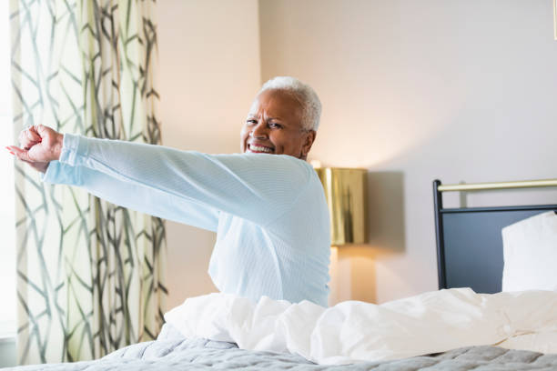 senior african-american woman waking up - sheet sleeping women bed imagens e fotografias de stock