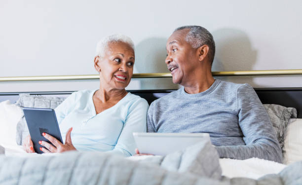 istock Senior African-American couple reading in bed, talking 1172340627