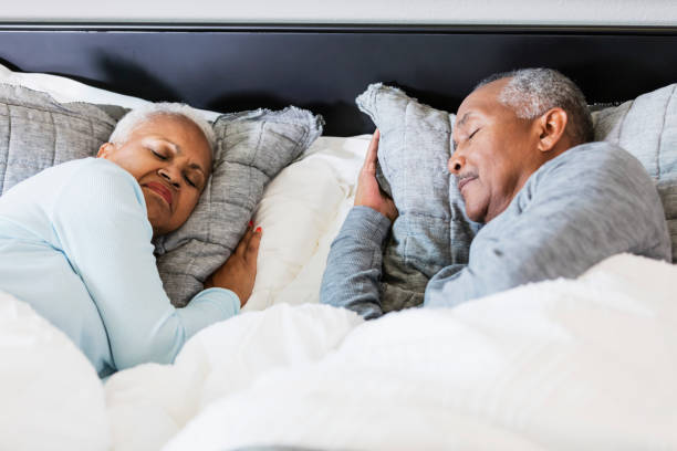 Senior African-American couple sleeping A senior African-American couple sleeping in bed. It is morning, time to get up soon. old man pajamas photos stock pictures, royalty-free photos & images