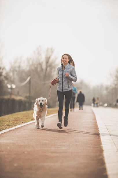 istock Happy woman taking her dog for a run 1172343363