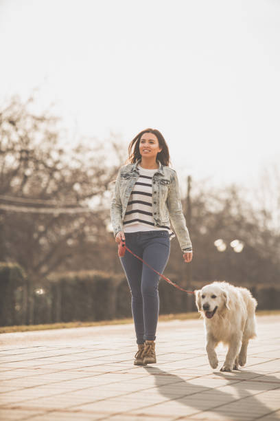 istock Woman taking her dog for a walk 1172343369