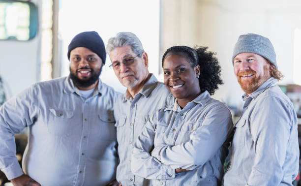 afroamerikanische frau und männliche mitarbeiter in derwerkstatt - horizontal female with group of males posing looking at camera stock-fotos und bilder