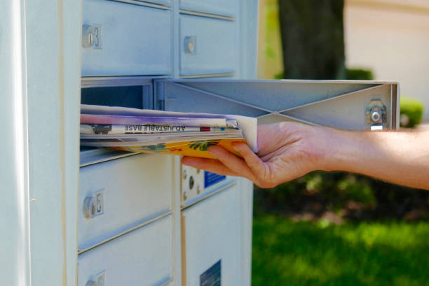 la main de la personne tirant le courrier hors d'une boîte aux lettres - courrier publicitaire photos et images de collection