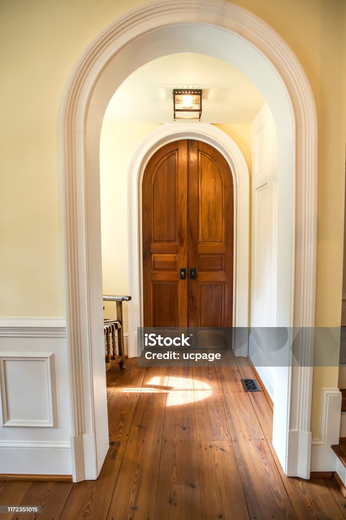 Home House Arch Door way entrance with solid wood stained curved interior doors Home House Arch Doorway entrance with solid wood stained curved interior doors Curve Stock Photo