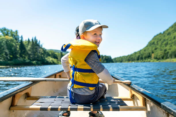 menino pequeno do redhead canoagem com sua família no parc national de la jacques cartier, quebec, canadá - summer family clothing exploration - fotografias e filmes do acervo