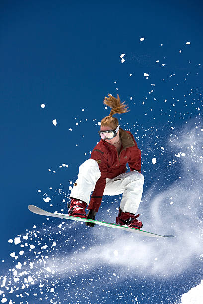 Female Snowboarder In Flight stock photo