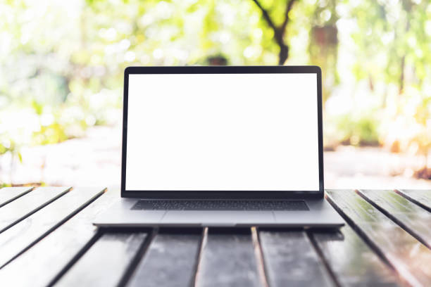 istock Blank screen laptop computer on wood table in outdoor cafe. 1172357126