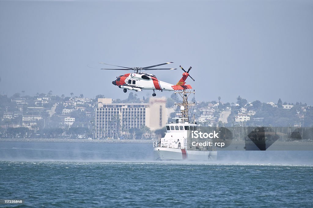 Coast Guard boat and helicopter in the bay Coast Guard Jayhwak Helicopter hovering over search and rescue boat Coast Guard Stock Photo