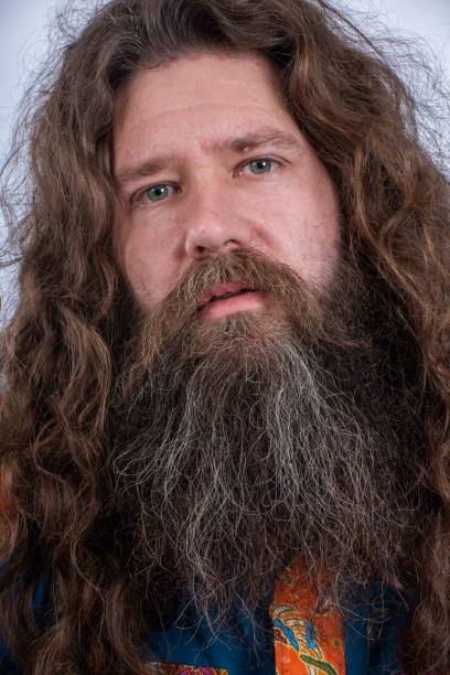 istock Young man with long hair and bushy beard looks into camera. 1172359963