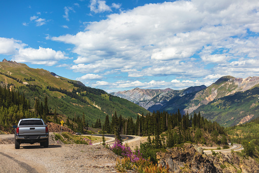 Pickup truck parked along paved highway on Western USA Road and in beautiful Mountain landscape overlooking Silverton Colorado (Shot with Canon 5DS 50.6mp photos professionally retouched - Lightroom / Photoshop - original size 5792 x 8688 downsampled as needed for clarity and select focus used for dramatic effect)