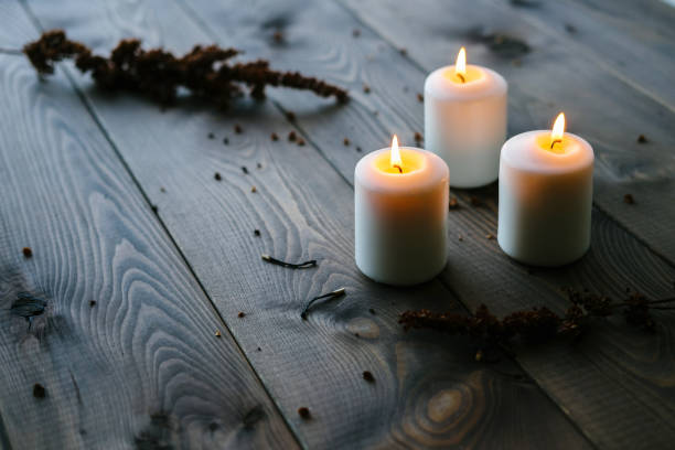 istock White Candles Burning On Wooden Tabletop 1172364336
