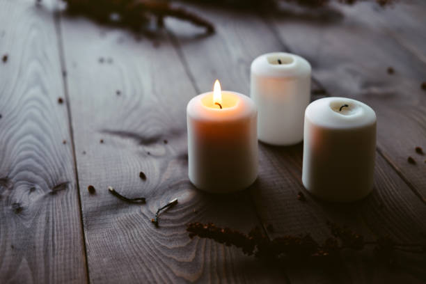 istock White Candles Burning On Wooden Tabletop 1172364383