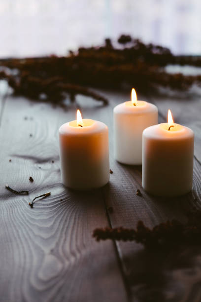 istock White Candles Burning On Wooden Tabletop 1172364748