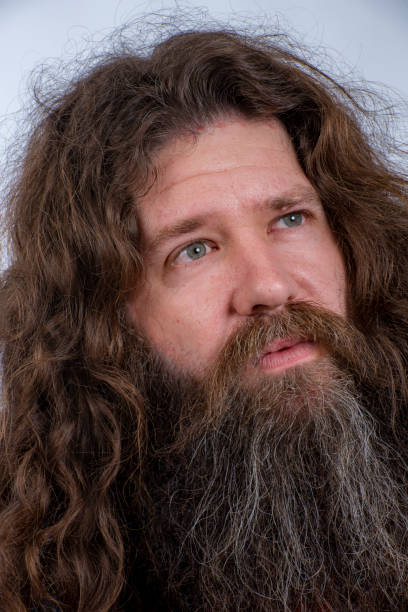 istock Young man with long hair and bushy beard ponders a problem to solve. 1172365845