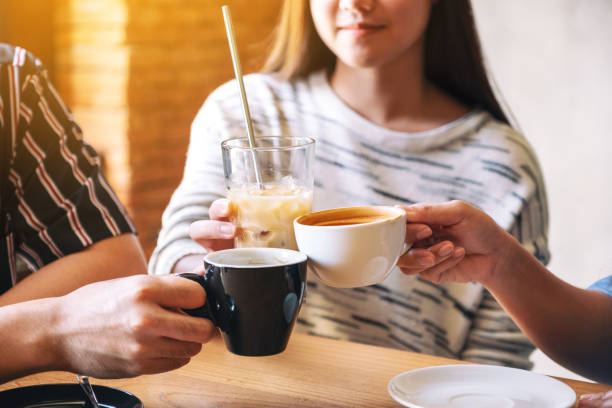 istock people clinking coffee cups on wooden table in cafe 1172369310