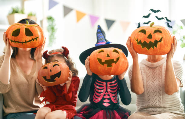 family celebrating Halloween Happy family celebrating Halloween. Grandmother, mother and children at home. carnival celebration event photos stock pictures, royalty-free photos & images