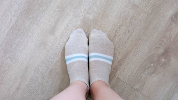 Beautiful young woman in bright brown short sock at home. Close Up selfie feet in warm socks standing on wooden background for winter. Beautiful young woman in bright brown short sock at home. Close Up selfie feet in warm socks standing on wooden background for winter. Top view. Beauty and fashion concept. asian women in stockings stock pictures, royalty-free photos & images